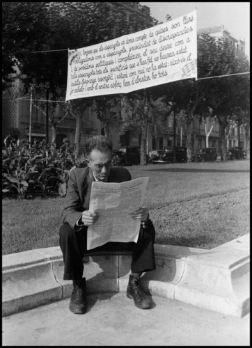 SPAIN. Barcelona. October- November 1936. The Spanish Civil War. Man reading under an anti-fascist banner.